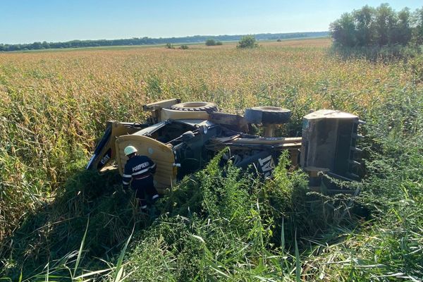 FOTO  Buldoexcavator răsturnat pe drumurile din Tulcea. Doi răniți